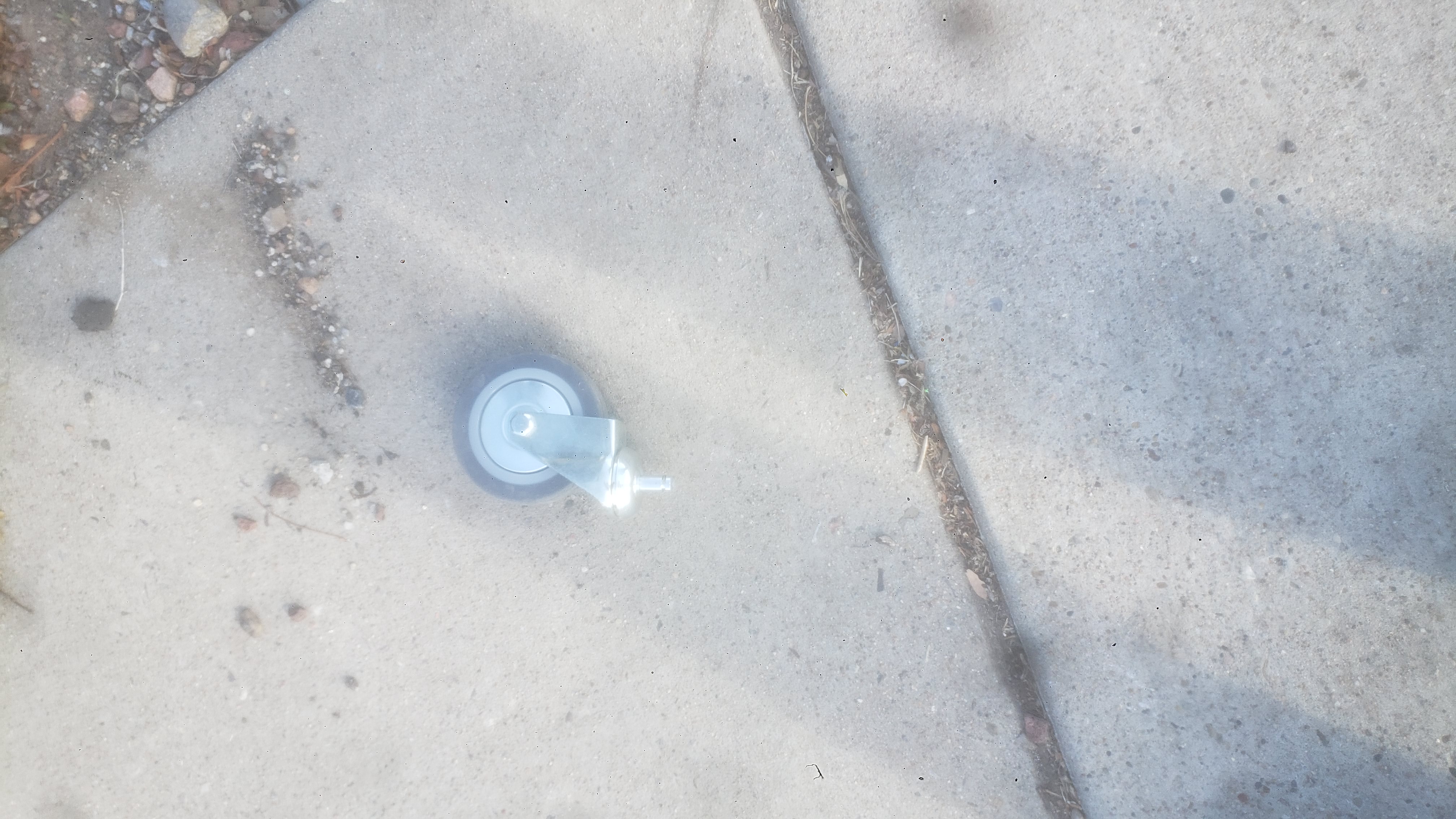 Shopping cart wheel on the side walk.